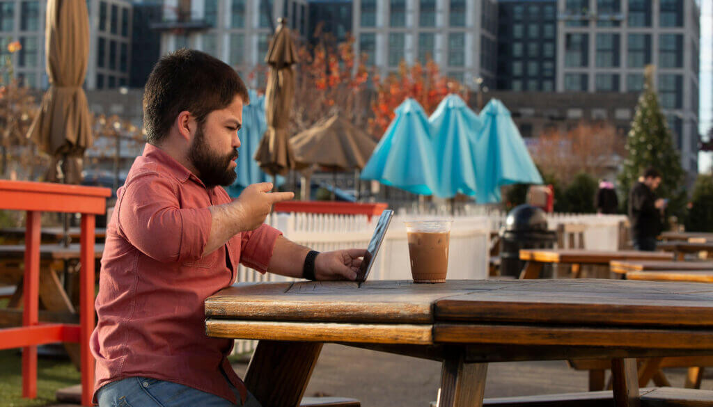 A man sitting on a table, signing to his phone